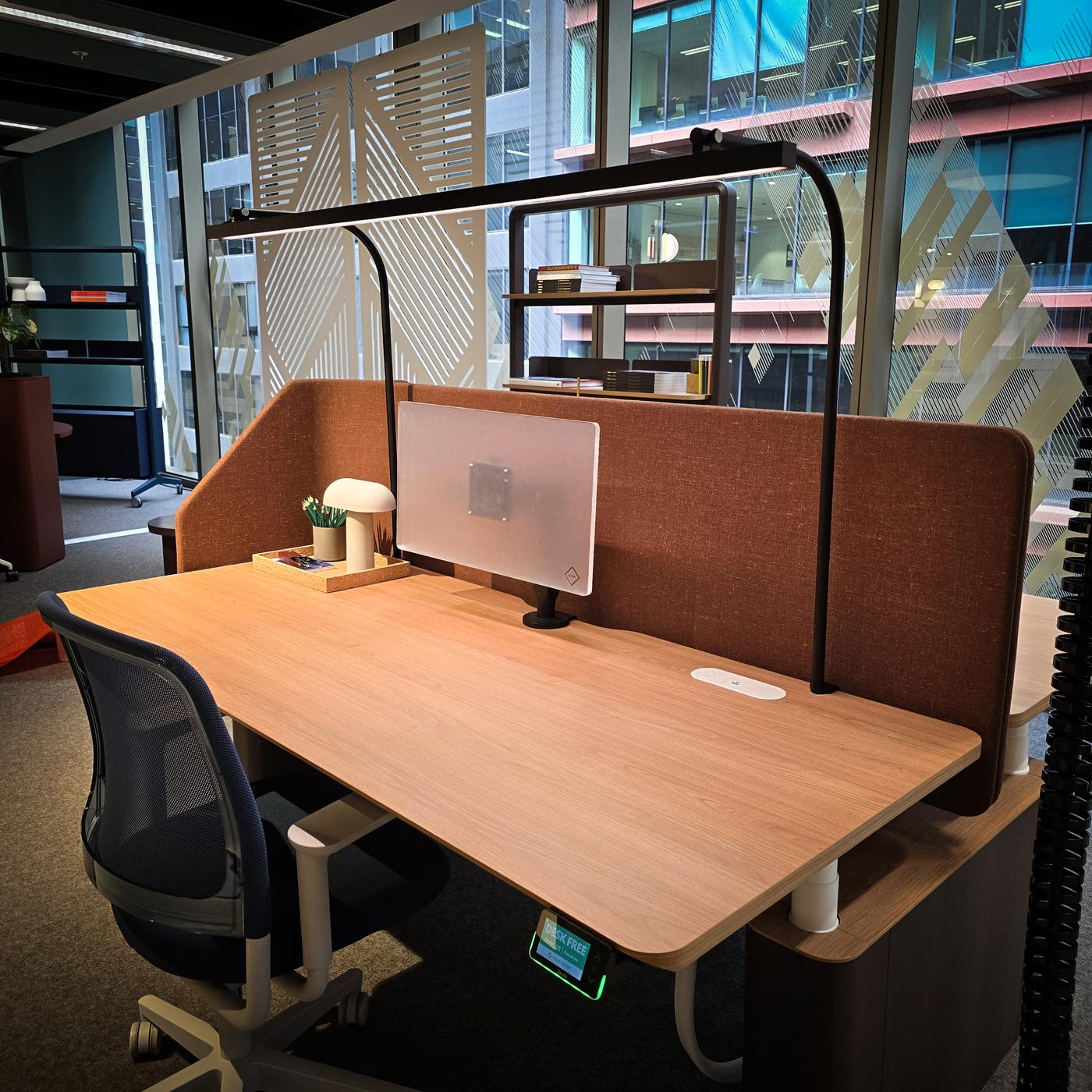 LightEFX Shift tunable desk light installed on a commercial office workstation with privacy partitions, touchpad controller visible on desk