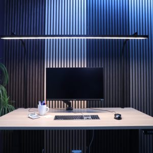 LightEFX Shift tunable desk light mounted on a timber workstation providing even glare-free illumination across the desk surface with monitor, keyboard and plant